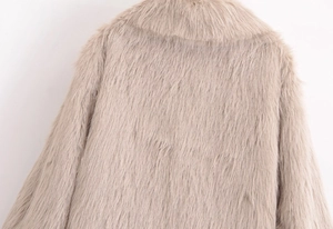 Detail of soft beige faux fur texture and lapel collar on this plush coat's back side