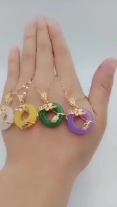 Detail of colorful round pendants in white, yellow, green, and purple on gold chains