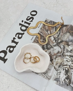 Flat gold snake chain necklace and vintage ring set with crystals on artistic tray