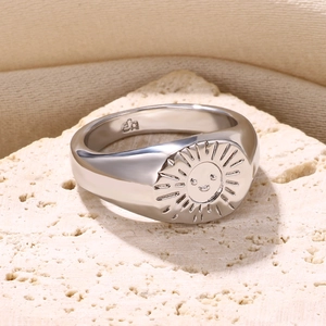 Macro shot of silver S925 signet ring with engraved smiling sun face on stone