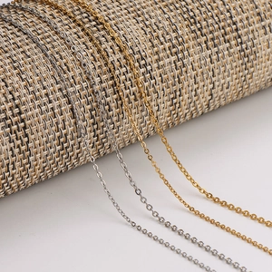 Close-up of gold and silver stainless steel cross chains on a textured display