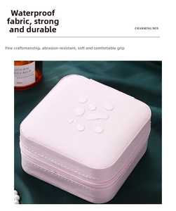 Close-up of pink waterproof jewelry box with zipper and water drops on fabric surface