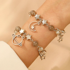Detailed close-up of beaded bracelets with silver-toned moon, star, and planet charms