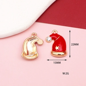 Macro detail of Christmas hat alloy charm with red enamel, gold star and crystal rhinestone