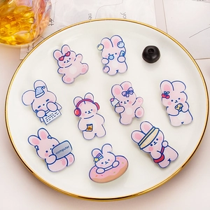 Set di nove graziose spille a forma di coniglio in acrilico rosa su un piatto bianco decorato