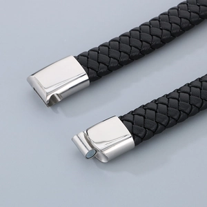 Close-up of black braided leather texture and silver magnetic clasp on men's bracelet
