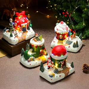 Detail view of four miniature glowing Christmas houses with LED lights and resin texture
