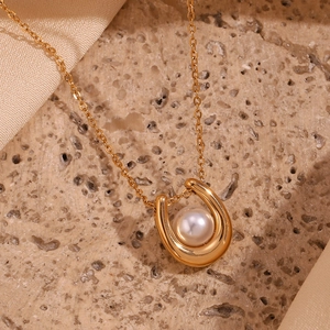 Detail of 18K gold-plated U-shaped pendant necklace featuring a lustrous white pearl center