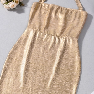 Detailed view of the gold metallic silk dress fabric with fine pleated texture and sheen
