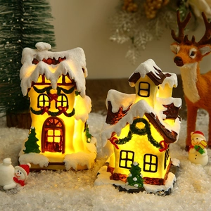 Detailed close-up of glowing resin Christmas village houses on a snowy miniature landscape