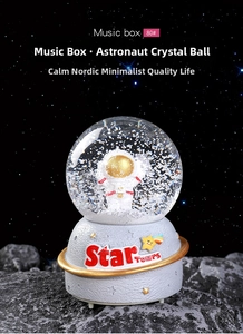 Macro shot of astronaut crystal ball music box with Star Tours moon base and snowflakes