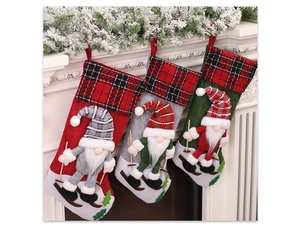 Three Christmas gnomes stockings in red, gray and green hanging on a white fireplace