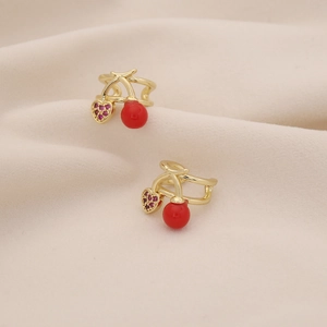 Close-up of gold cherry ear cuffs with red beads and pink rhinestone heart details