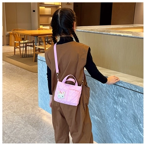 Borsa a tracolla trapuntata rosa per bambina con ciondolo a coniglio bianco indossata
