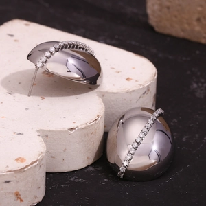 Detailed view of silver dome earrings featuring vertically set white zircon stones
