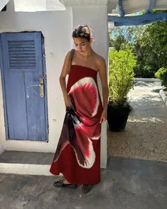 Detail of red floral tube maxi dress showing abstract patterns in Mediterranean garden