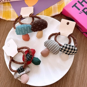 Close-up of cute mushroom pendant hair ties with checkered and striped fabric patterns