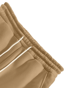 Detail of khaki jogger pants featuring an elastic waistband and white drawstring ties