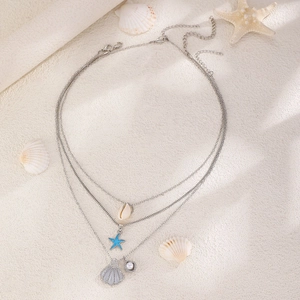 Dettaglio collana triplo strato argento con ciondoli a stella marina, conchiglia e perla