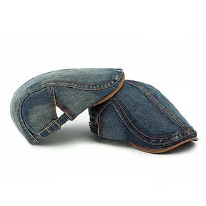 Washed denim flat cap in retro British style with vintage orange stitching and metal buckle