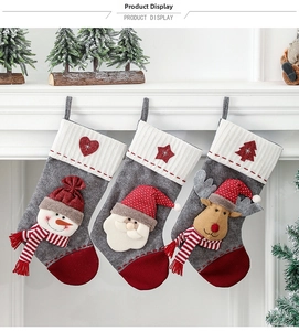 Détail de trois chaussettes de Noël suspendues avec bonhomme de neige 3D, Père Noël et renne