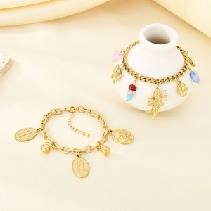 Elegant gold stainless steel bracelets with cross, cupid, and beaded charms on a white vase