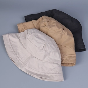 Close-up of three folded cotton bucket hats in black, khaki and beige with stitching
