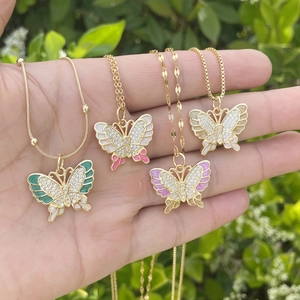 Golden butterfly pendant necklaces with enamel and zircon inlay held in hand