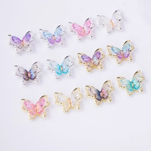 Close-up of laser resin butterflies in gold and silver frames for luxury nail art DIY