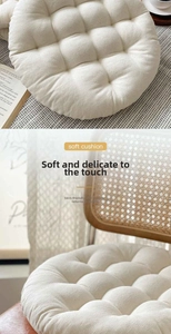 Close-up of beige round tufted seat cushion with cotton linen texture and thick padding