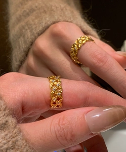 Detail of gold-plated hollow ring with cubic zirconia stones worn on models finger