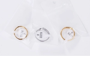Close-up of gold and silver V-shaped rings with size labels 7 and 8 in packaging
