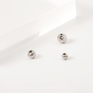 Close-up of three hammered texture stainless steel spacer beads with holes for DIY jewelry