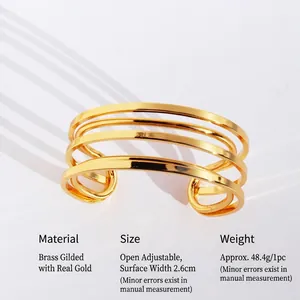 Luxurious wide open cuff bracelet made of gold-plated brass with a layered geometry design