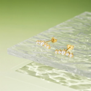 Close-up of S925 silver gold-plated stud earrings with pear-cut zircon and white pearls