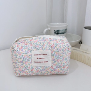 Vue détaillée d'une trousse à maquillage fleurie matelassée avec fermeture éclair