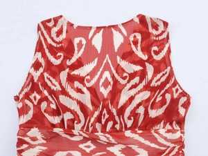 Détail d'une robe longue en mousseline à imprimé ikat rouge et blanc sans manches plissée