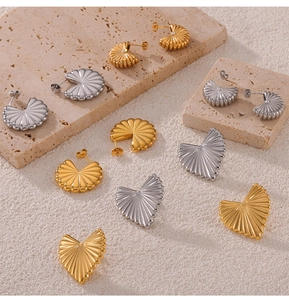 Detailed macro shot of vintage gold heart earrings with pleated radial texture design