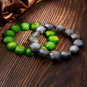 Detail of bohemian stretch bracelets with emerald green and grey blue faceted beads