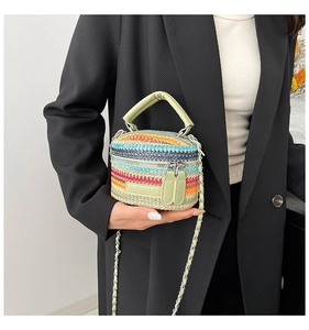 Dettaglio della borsa intrecciata colorata con finiture in pelle verde menta e catena
