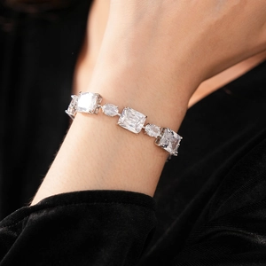 Detailed view of silver bracelet featuring large clear geometric cut zircon stones on wrist