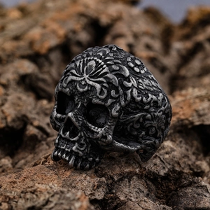 Macro shot of vintage skull ring with detailed engravings on rustic bark background