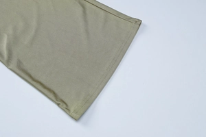 Macro detail showing double-needle stitching on olive green fabric hem of women's set