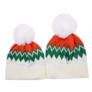 Detail of red and green zigzag knit pattern on parent-child beanies with white pom-pom