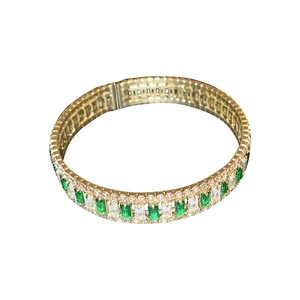 Goldenes Armband mit grünen Edelsteinen im Smaragdschliff und funkelnden weißen Zirkonia