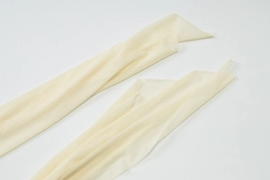 Detailansicht der cremefarbenen Mesh-Armstulpen mit feiner Textur und Stoffstruktur