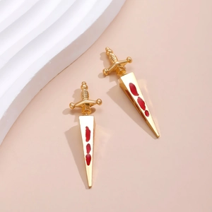 Detail of gothic sword earrings with red enamel blood effect on gold-tone metal