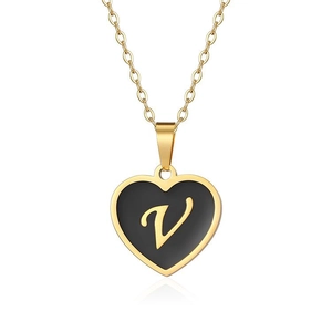 Macro detail of a golden heart pendant with black enamel finish and gold letter V engraving