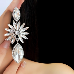 Gros plan de boucles d'oreilles pendantes argentées avec strass fleuris et cristaux