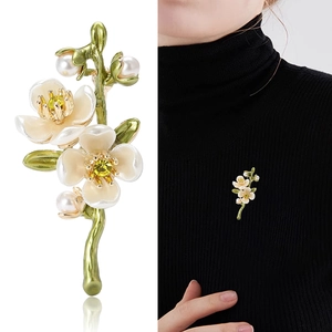 Elegant plum blossom branch brooch with white flowers, pearls and green branch on model